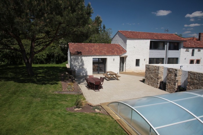 Extérieur du gite avec la piscine en premier plan